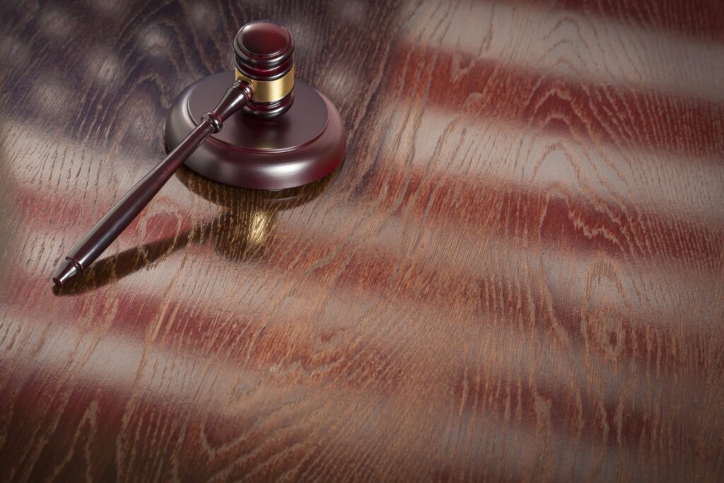 Wooden Gavel Resting Flag Reflecting Table Scaled.jpg